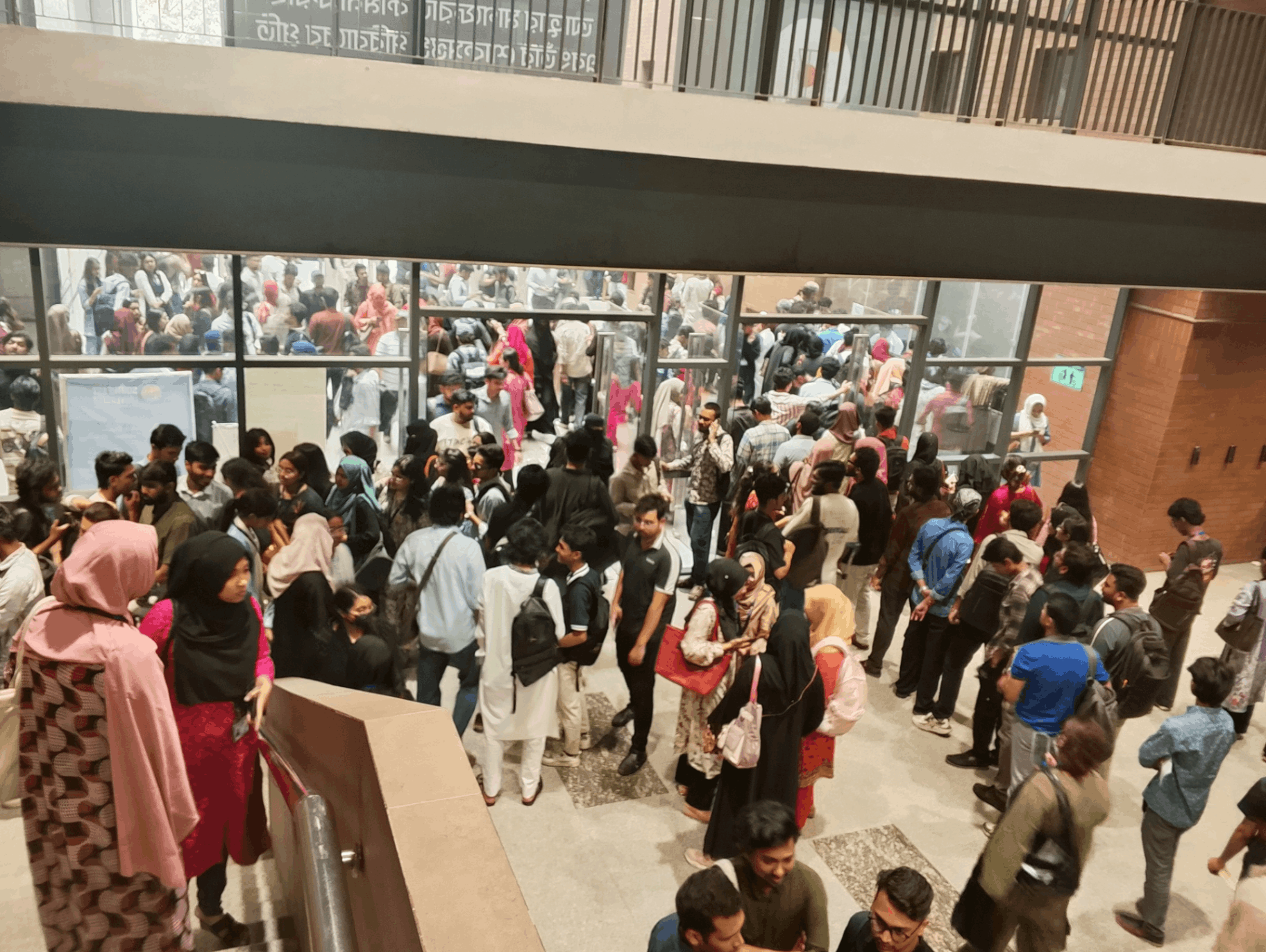 View from the stairs - students packed in the open area between the cafeteria, lift, bank and main entrance on payment day.